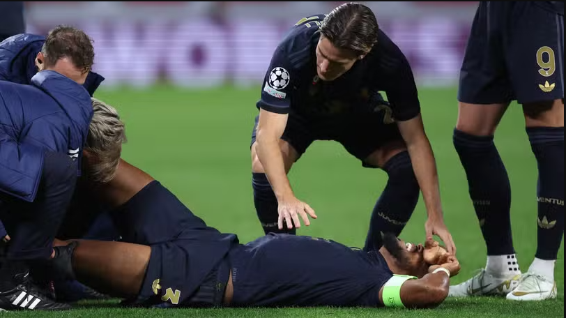 Jogador machucado deitado no campo.